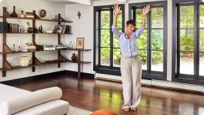 Woman happily waving her arms in clean living room after junk removal service by 1-800-GOT-JUNK?