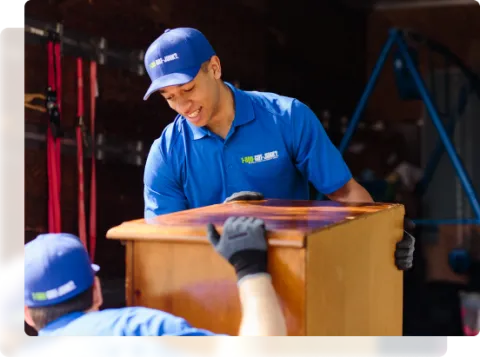 1-800-GOT-JUNK? team lifting dresser drawers onto junk removal truck