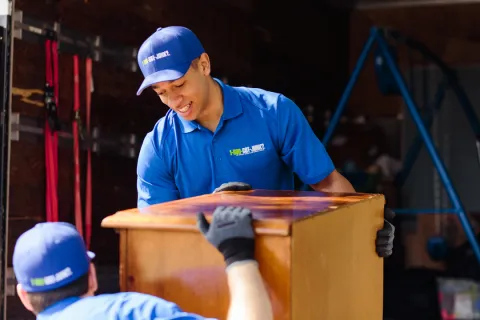 1-800-GOT-JUNK? team lifting dresser drawers onto junk removal truck