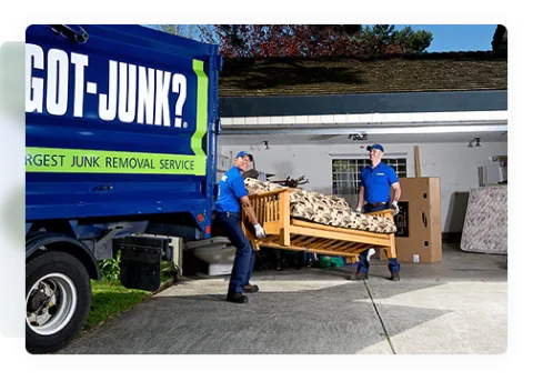 1-800-GOT-JUNK? team picking up old couch to put in junk removal truck