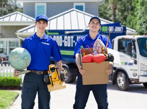 two men holding a box of old stuff and an old globe